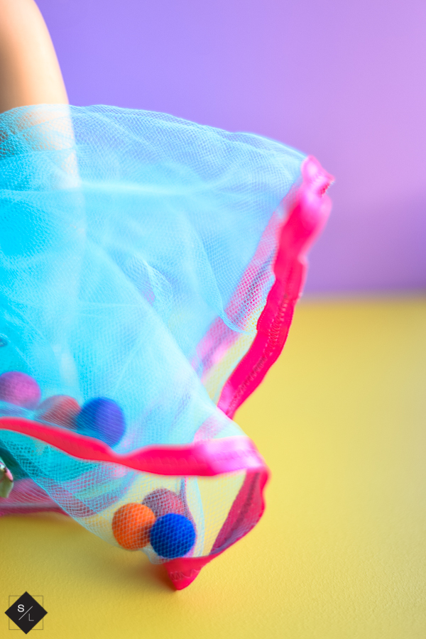 pom poms in a tulle skirt for doll DIY American Girl Doll Birthday Outfit created with the Cricut Maker. #americangirlclothes #cricutmaker #sewing #dollclothes